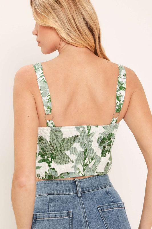 Woman wearing a floral top and jeans on a plain background