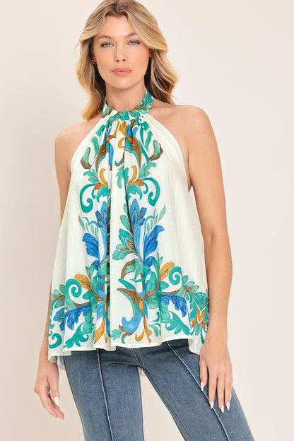 Woman wearing a floral halter top and jeans on a plain background