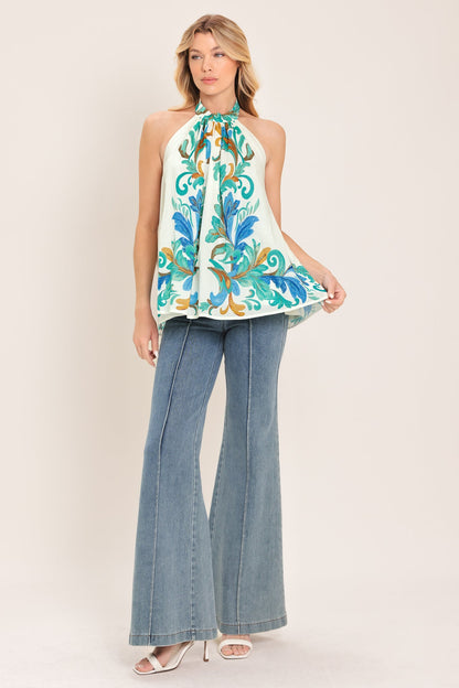 Woman wearing a sleeveless floral top and denim jeans on a white background