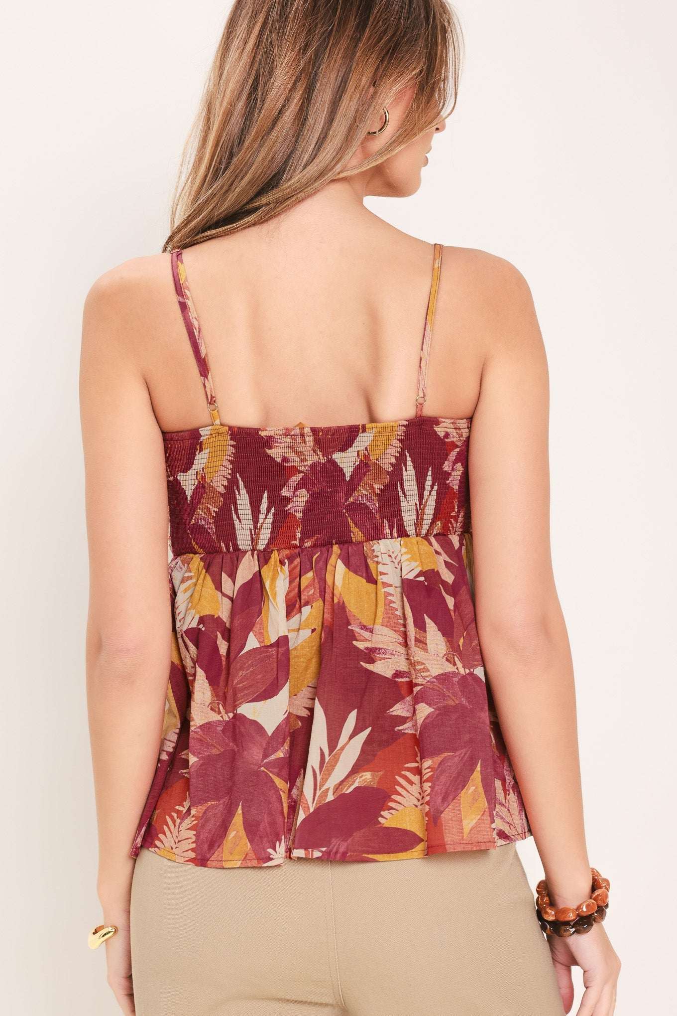 Woman wearing a floral patterned top with a plain background