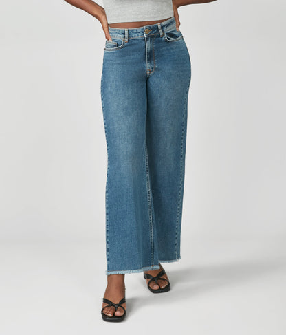 Person wearing blue jeans on a white background