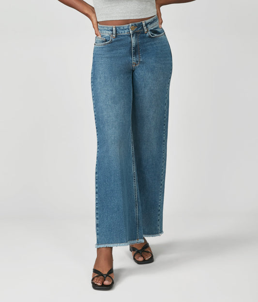 Person wearing blue jeans on a white background