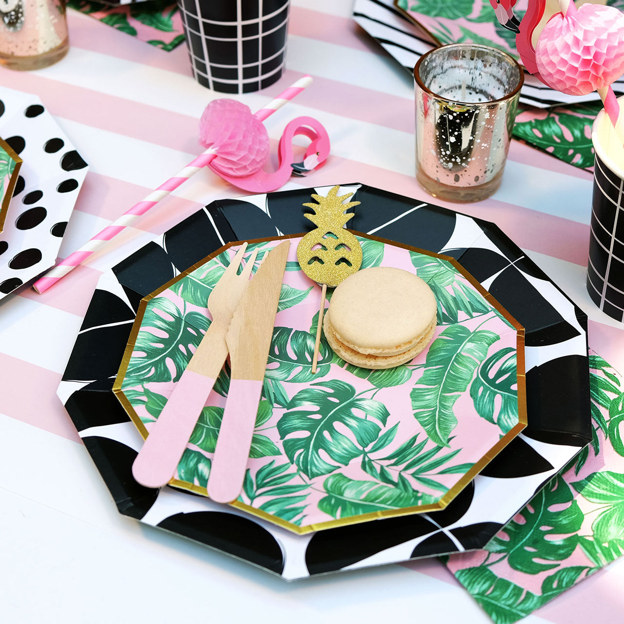 Tropical theme party table setting featuring pink flamingo paper drinking straws.