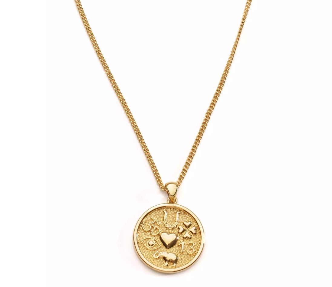 Gold necklace with a round pendant on a white background