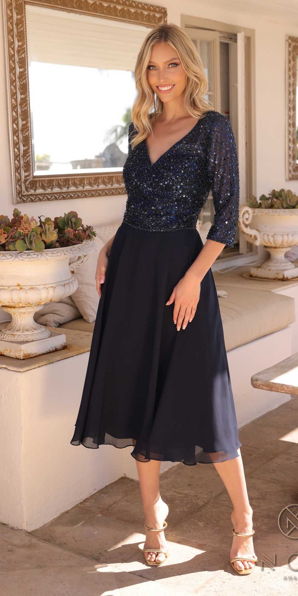Woman wearing a black and blue dress in an elegant indoor setting.