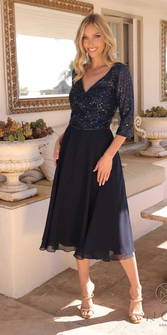Woman wearing a black and blue dress in an elegant indoor setting.