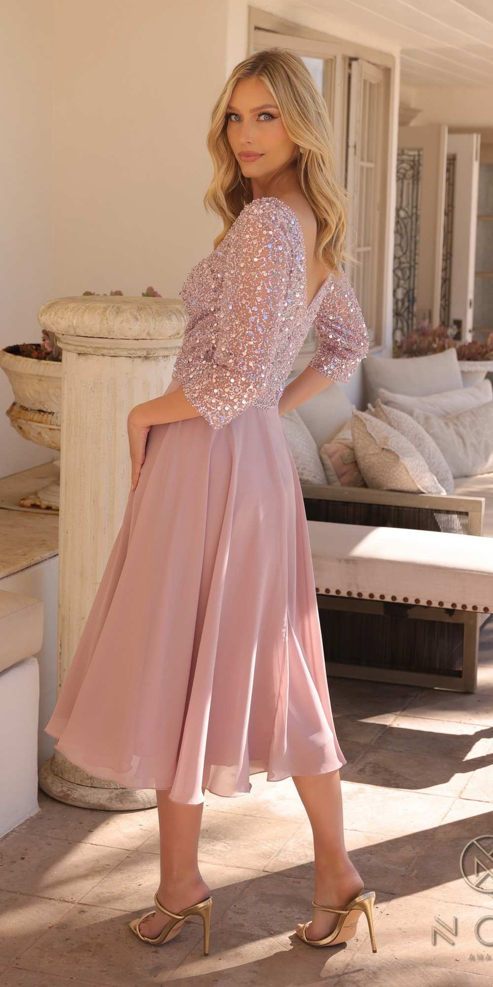 Woman wearing a pink dress with sequin detailing in an outdoor setting.