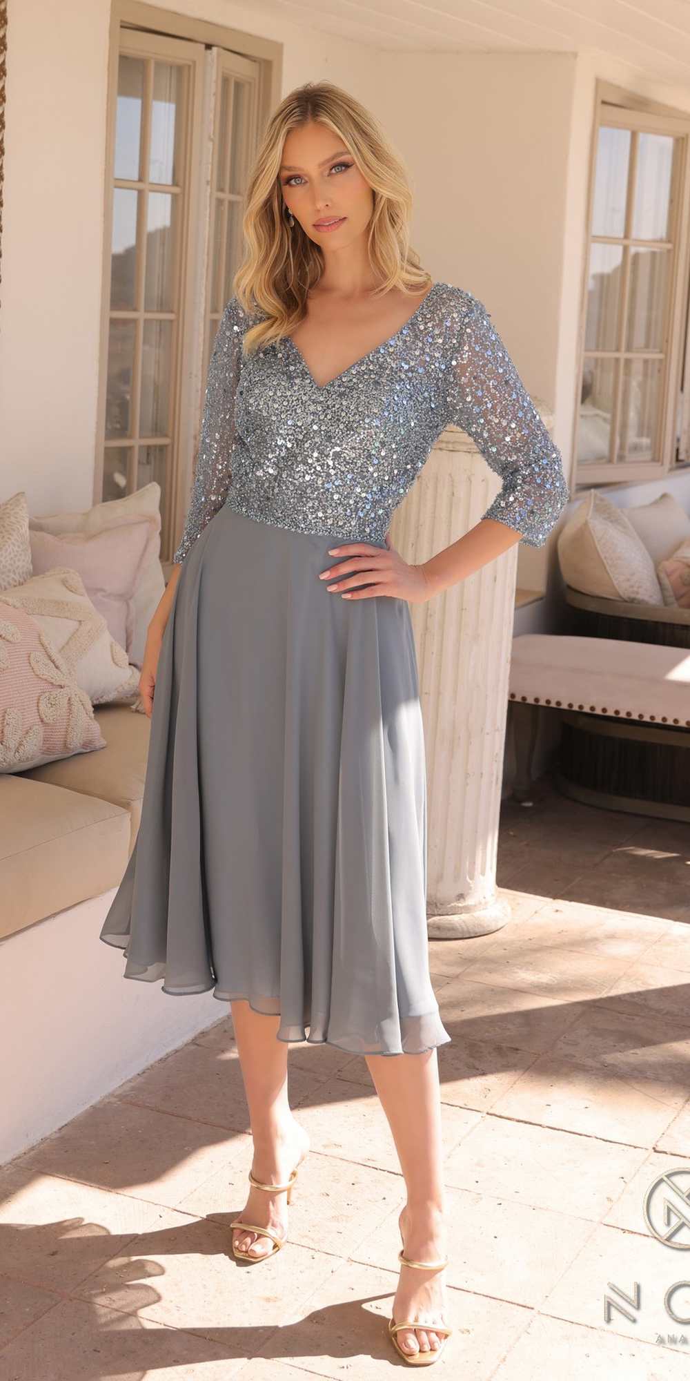 Woman wearing a light blue sequin dress standing outdoors.