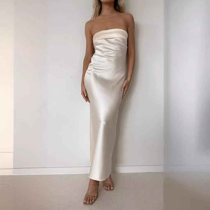 Satin strapless backless midi dress in cream, featuring a side slit and fitted silhouette, worn by a model.