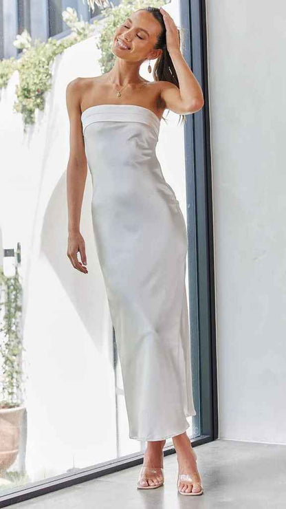 Satin strapless backless midi dress with a side slit, displayed on a model in a bright indoor setting.