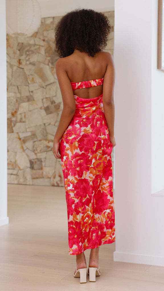 Satin strapless backless midi dress with a floral pattern in red and orange, featuring a side slit and fitted silhouette.