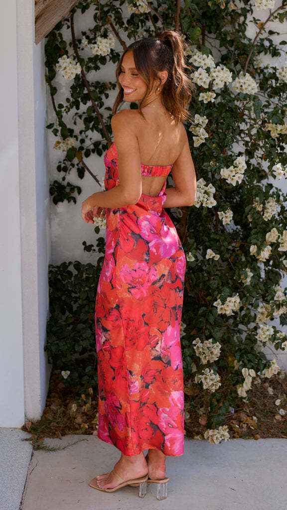 Satin strapless backless midi dress with a floral pink and orange pattern, featuring a side slit and fitted silhouette.