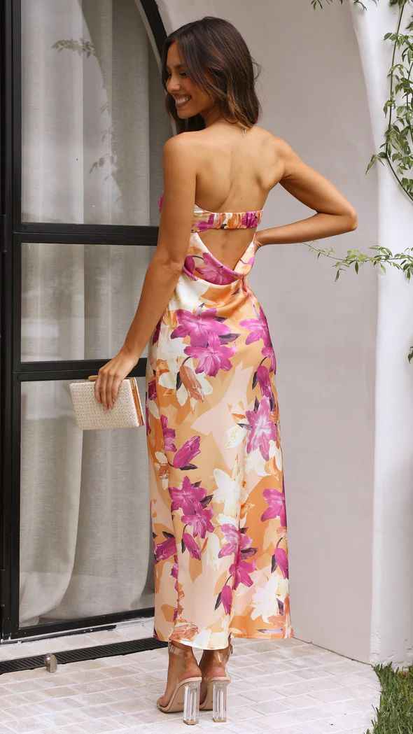 Satin strapless backless midi dress with floral print, featuring a side slit and a model holding a clutch.