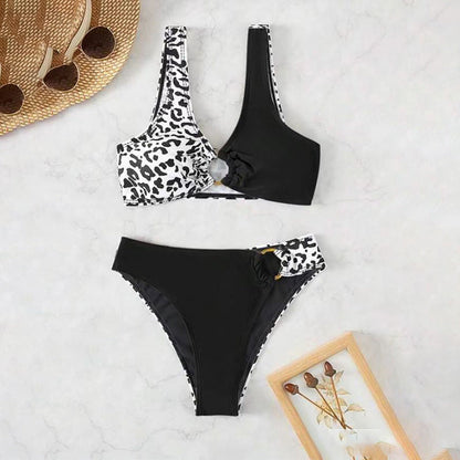 Split swimsuit featuring leopard print and contrasting black color, with a unique design and high-waisted bottom.