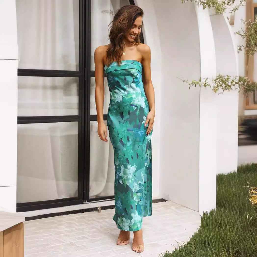 Satin strapless backless midi dress with a green floral pattern, worn by a model standing outdoors.