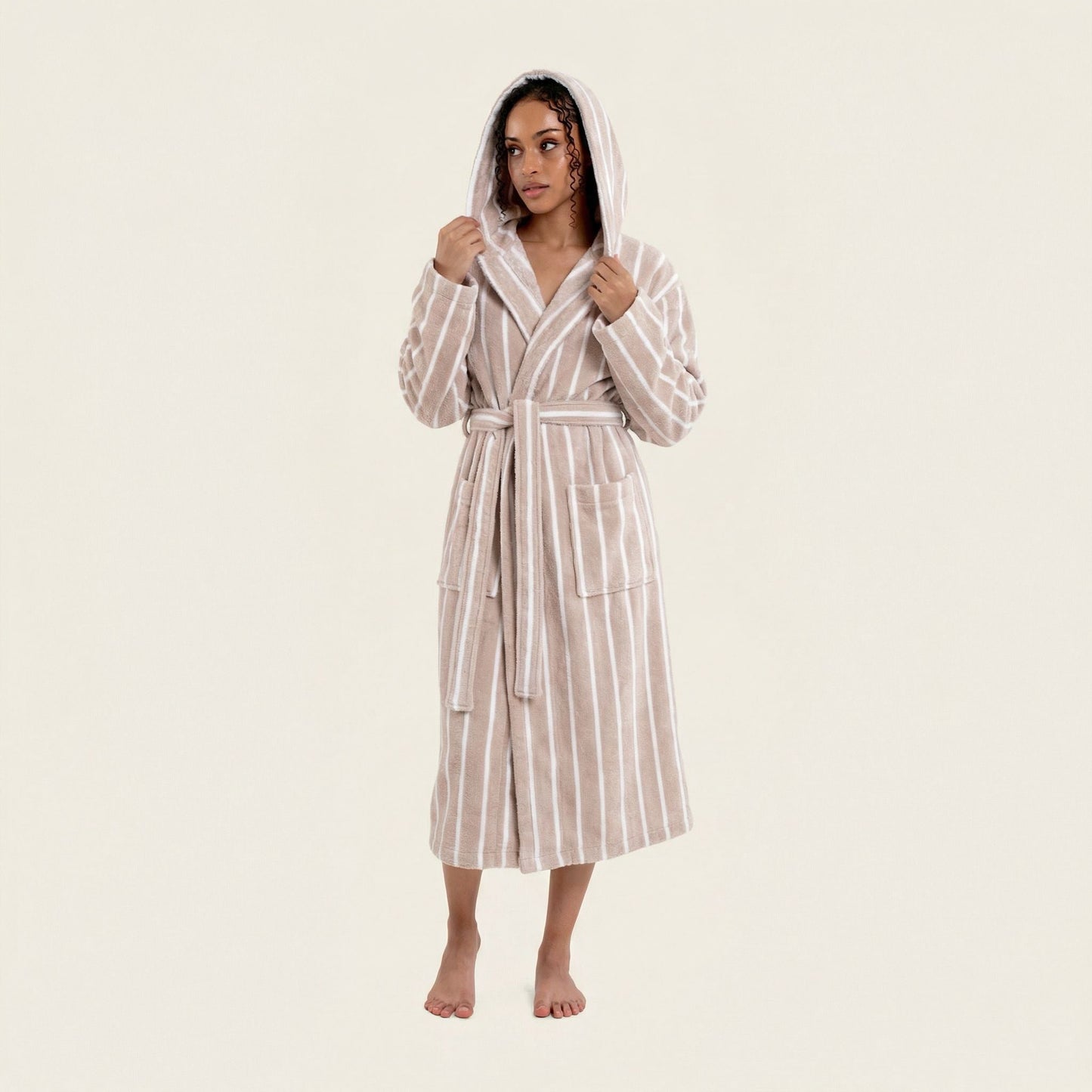 Woman wearing a striped robe on a plain background