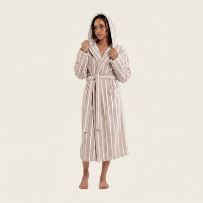 Woman wearing a striped robe on a plain background