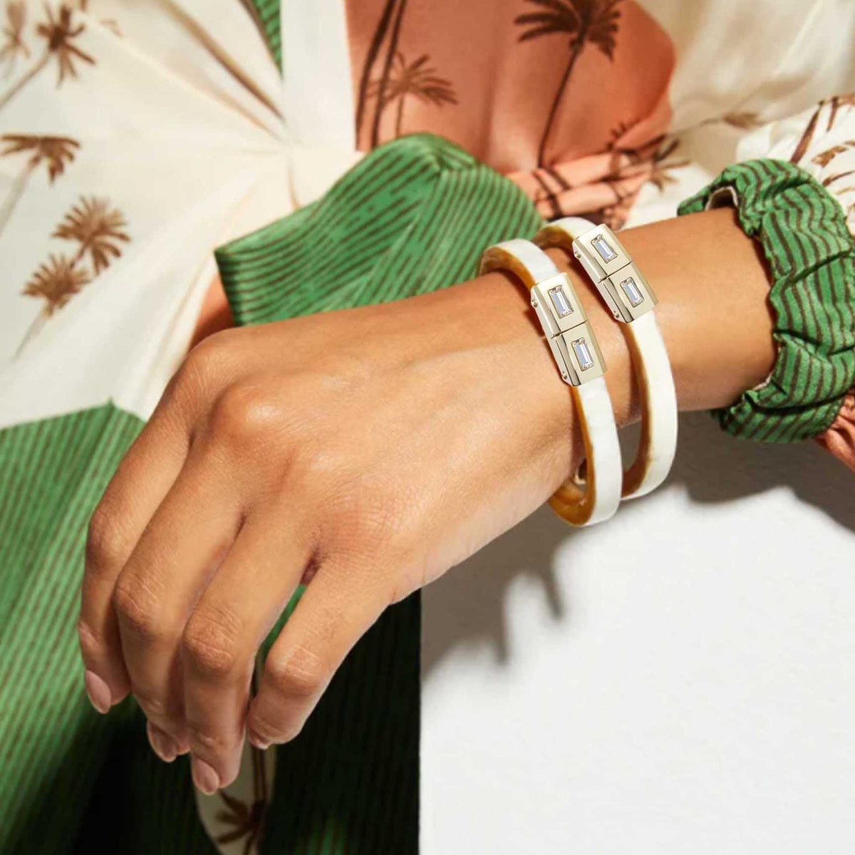Close-up of a wrist wearing multiple bracelets with a blurred background