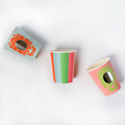 Three colorful paper cups with striped and ornate frame patterns arranged on a white background.
