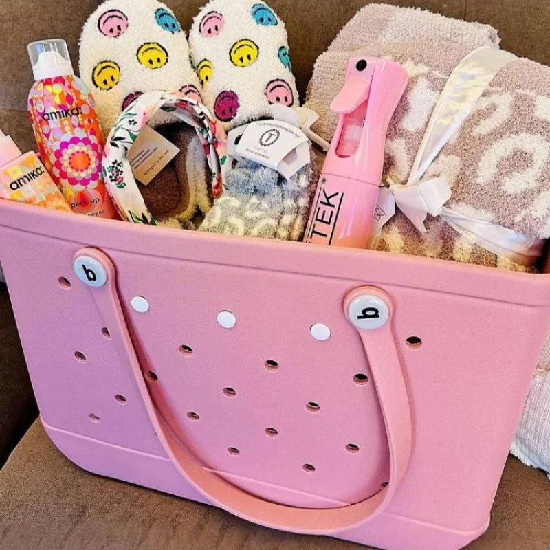 Pink tote bag filled with various items including a bottle, towel, and slippers.