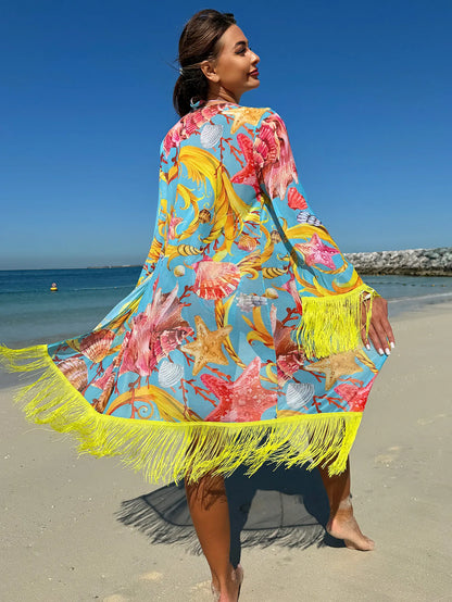Blue fabric cover-up with seashell and starfish print and yellow fringe trim worn on a beach.