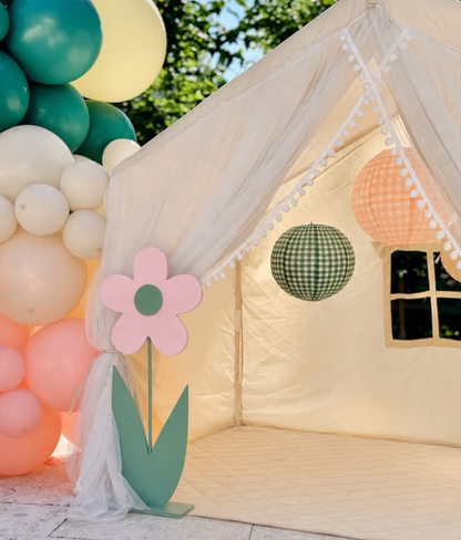 Children's play tent with decorative elements and balloons in the background