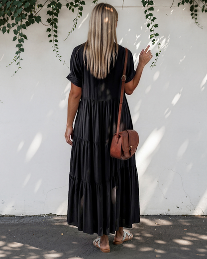 Model wearing a short sleeve tiered maxi dress, back view