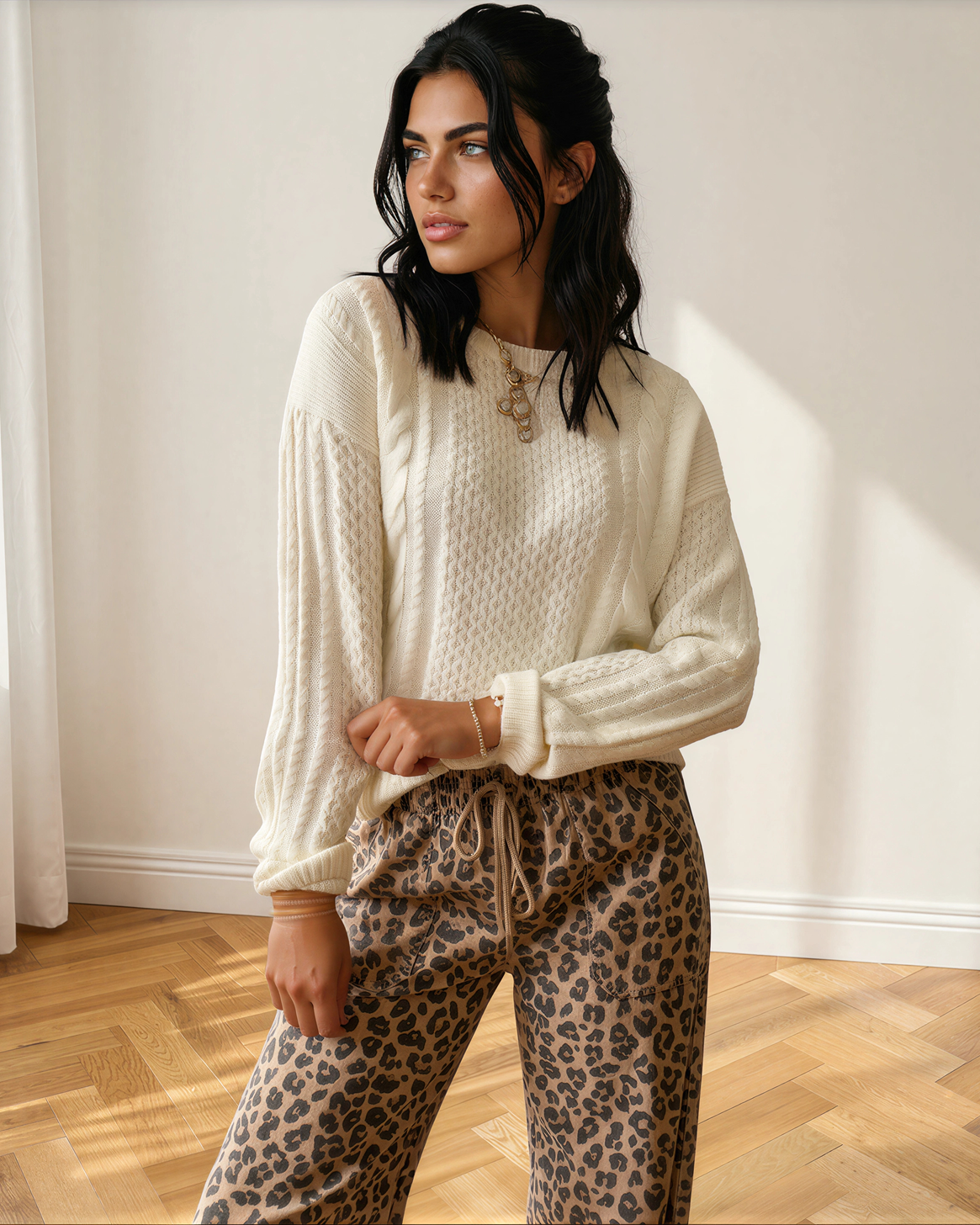 Model wearing a cable knit sweater in cream