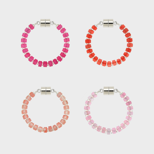 Set of four beaded hoop wine glass markers in pink, red, and peach on a white background