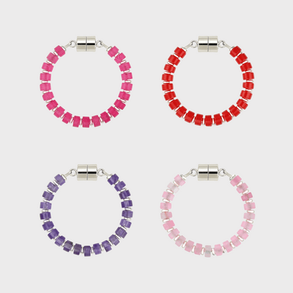 Four circular wine charms with pink, red, purple, and light pink beads and silver magnetic clasps.
