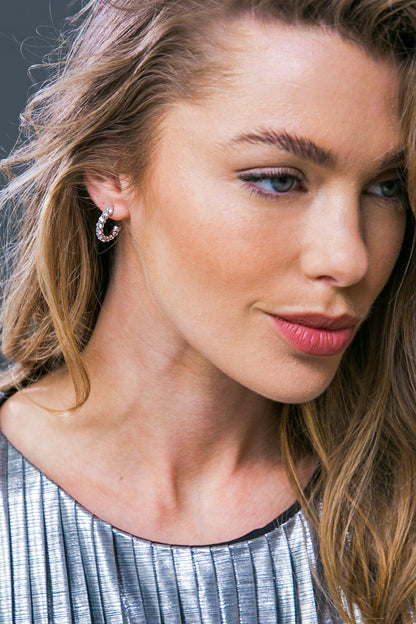 Close-up of a woman with blonde hair and blue eyes, wearing a silver earring.