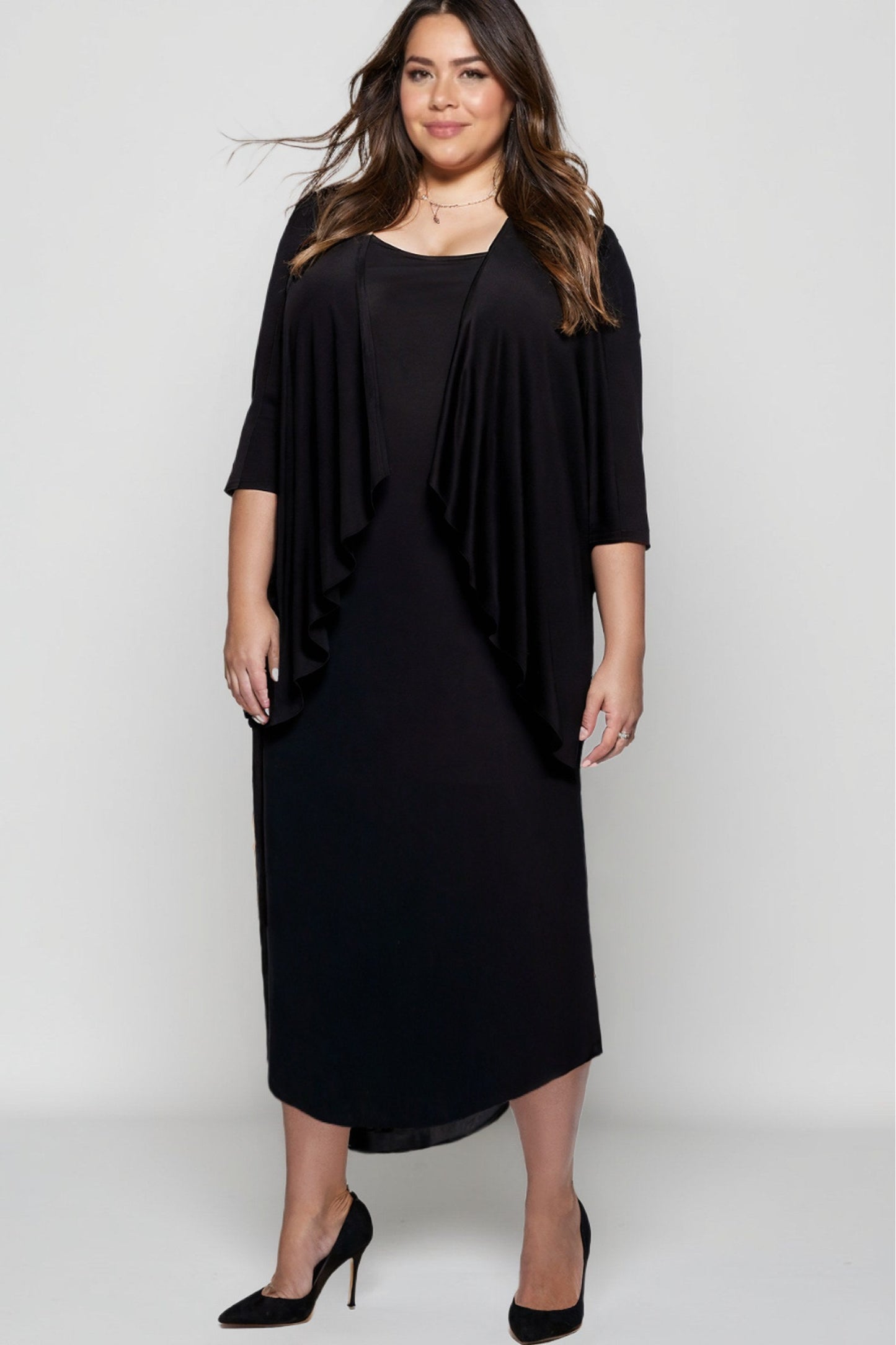Woman wearing a black dress with a draped effect on a white background