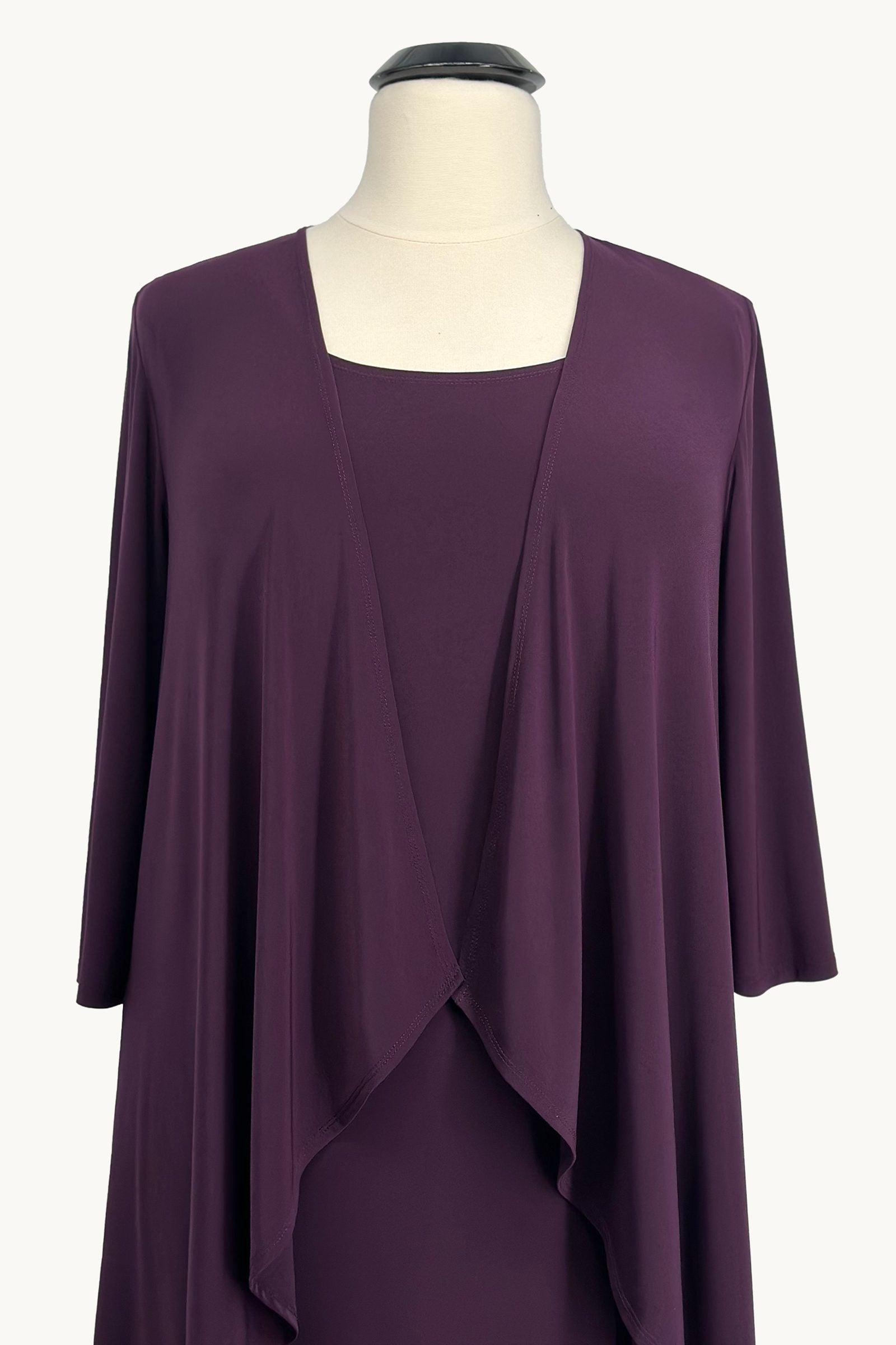 Purple dress with matching jacket on a mannequin against a white background