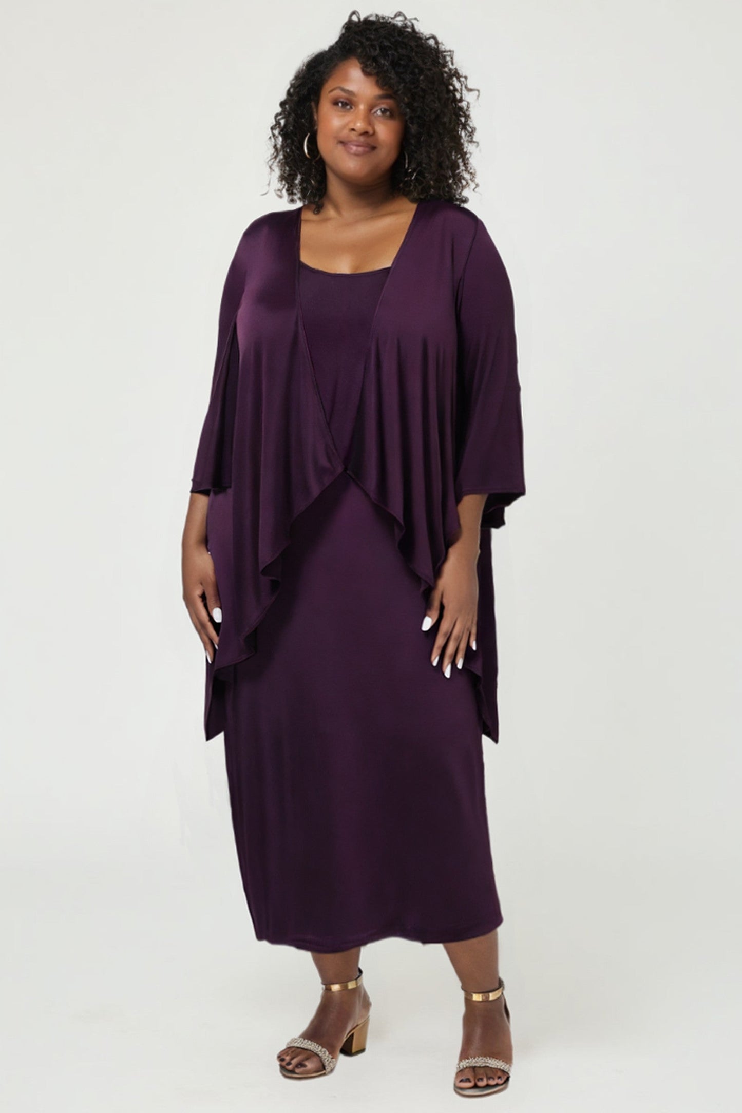 Woman wearing a purple dress with a matching jacket on a white background
