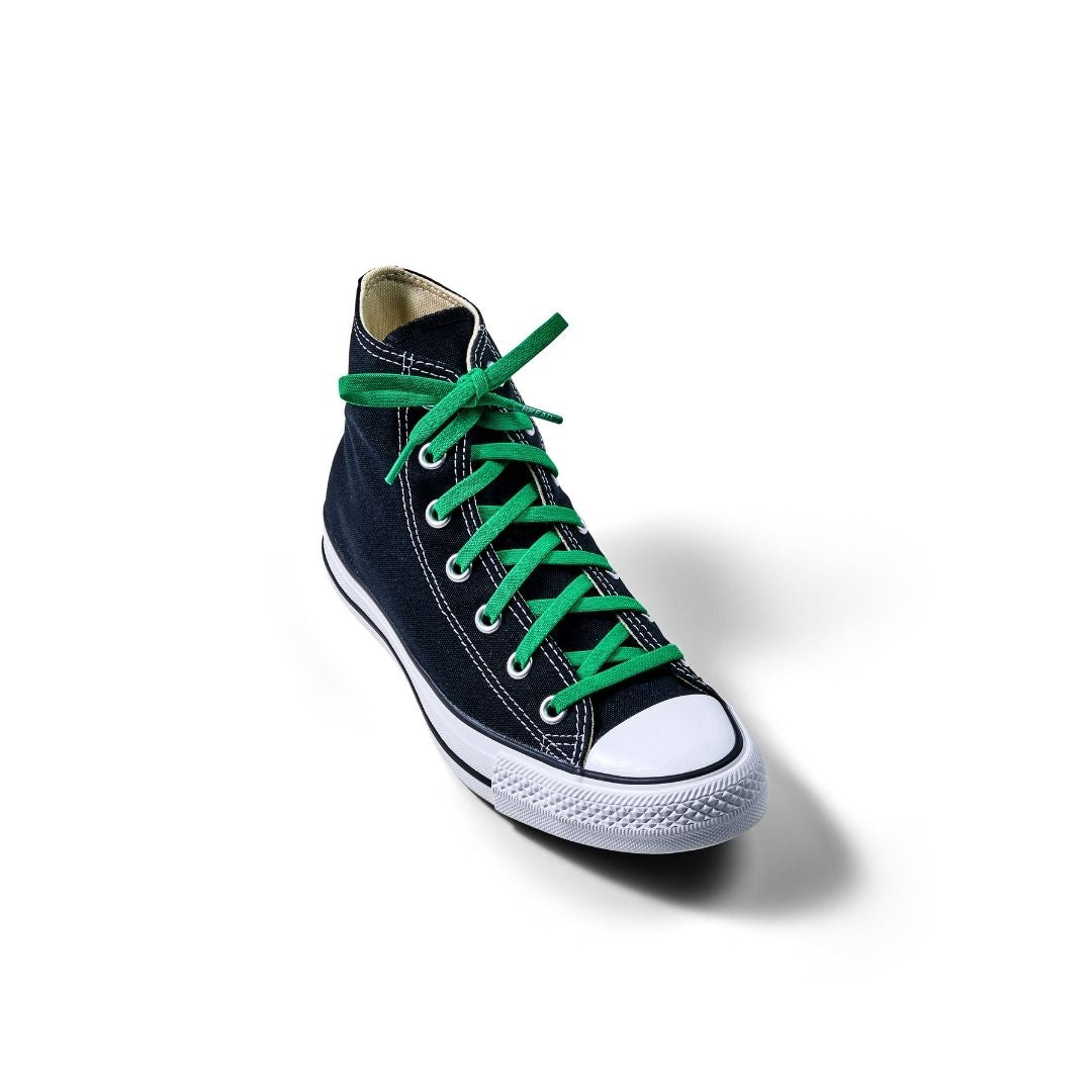 Lucky Green Shoe Laces from Bread laced through a black high-top sneaker, featuring a white rubber sole and toe cap.