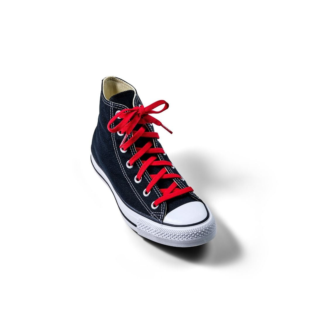 Bold red elastic shoelaces on a black high-top sneaker with white sole and toe cap, positioned on a white background.