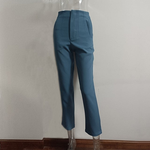 Teal pants on a transparent mannequin against a plain background