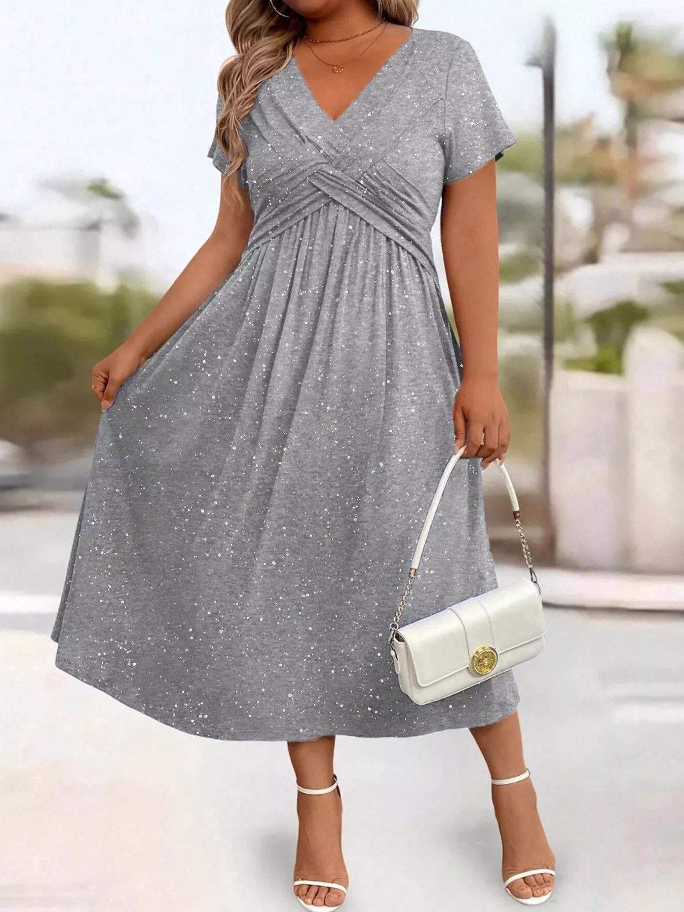 Woman wearing a gray dress with a blurred outdoor background
