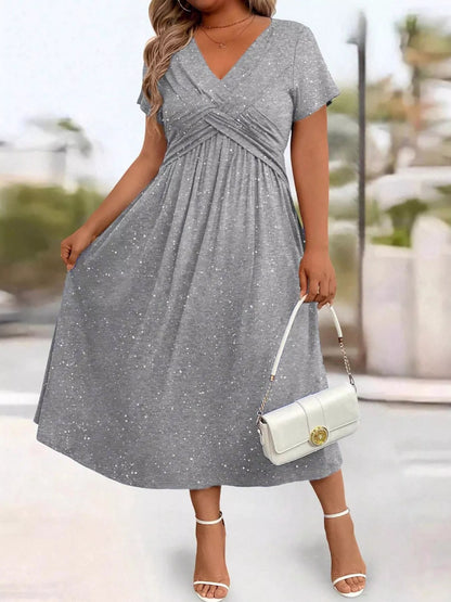 Woman wearing a gray dress with a blurred outdoor background