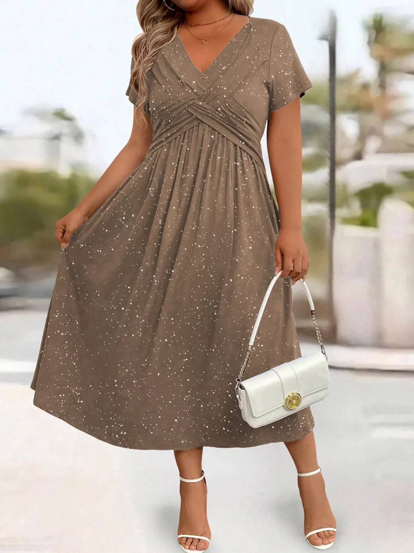 Woman wearing a brown dress with a white handbag outdoors