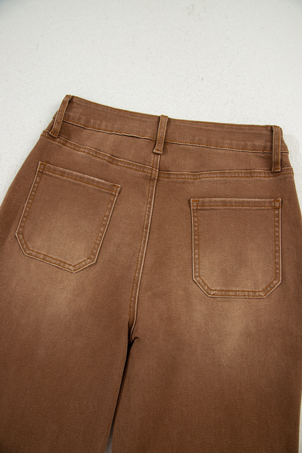 Flat lay of brown wide leg cropped jeans.