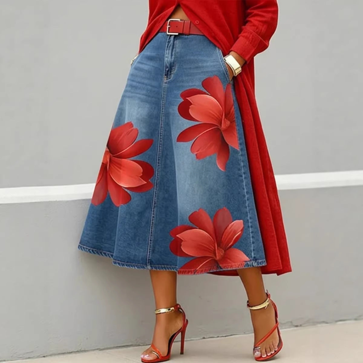 Person wearing a red floral denim skirt with a red top and high heels on a gray background