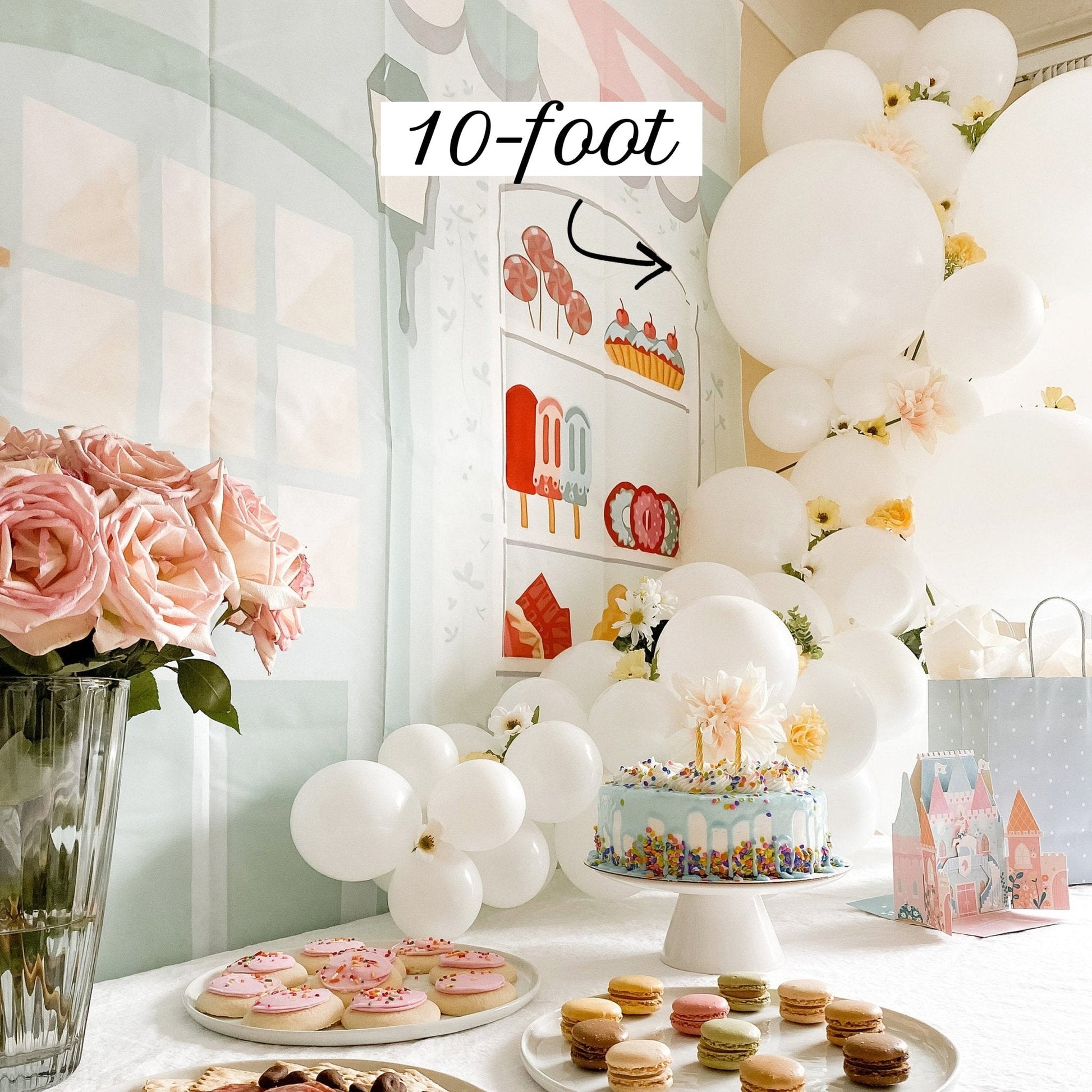 Decorated birthday party setup with balloons, cake, and flowers in a room.