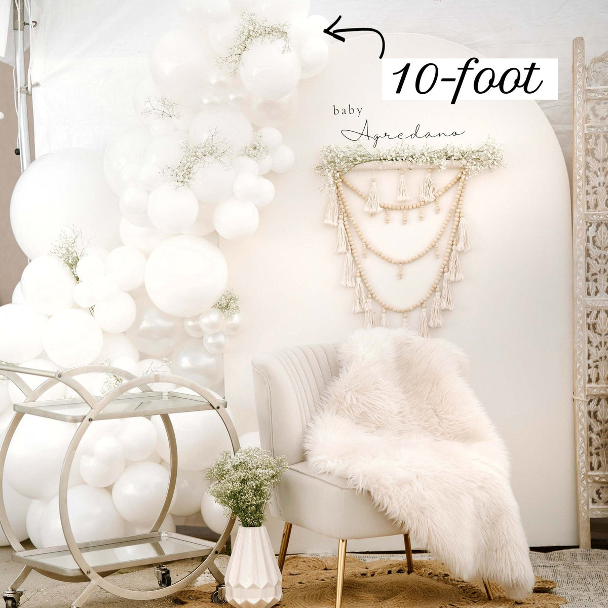 Decorative setup with balloons, a chair, and a decorative wall hanging in a room.