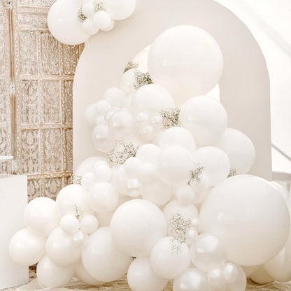 White balloon arch with decorative elements in a room setting