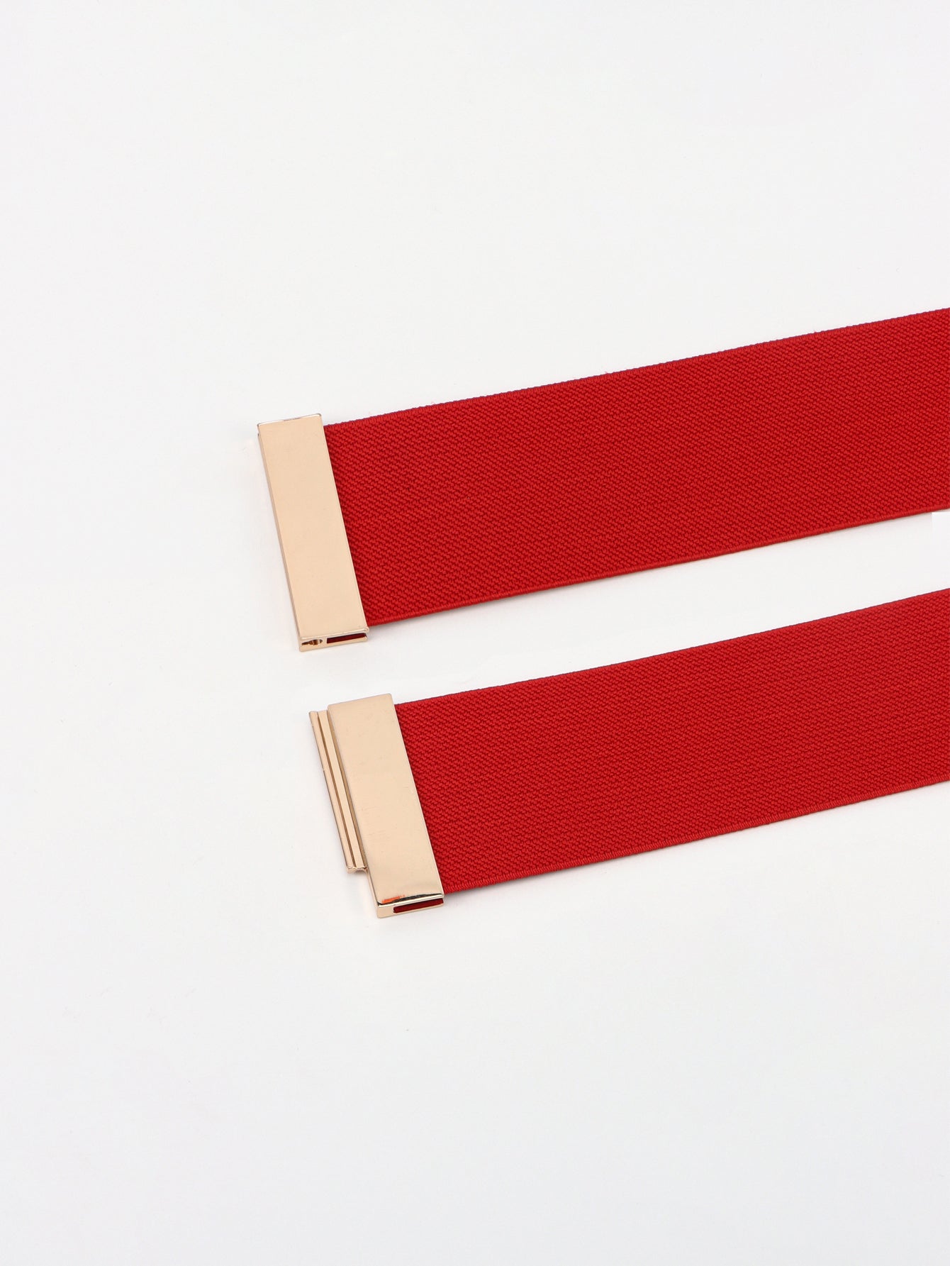 Two red belts with gold buckles on a white background