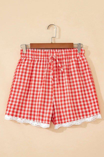 Red and white gingham fabric shorts with an elastic tie waist and white lace trim at the hem.