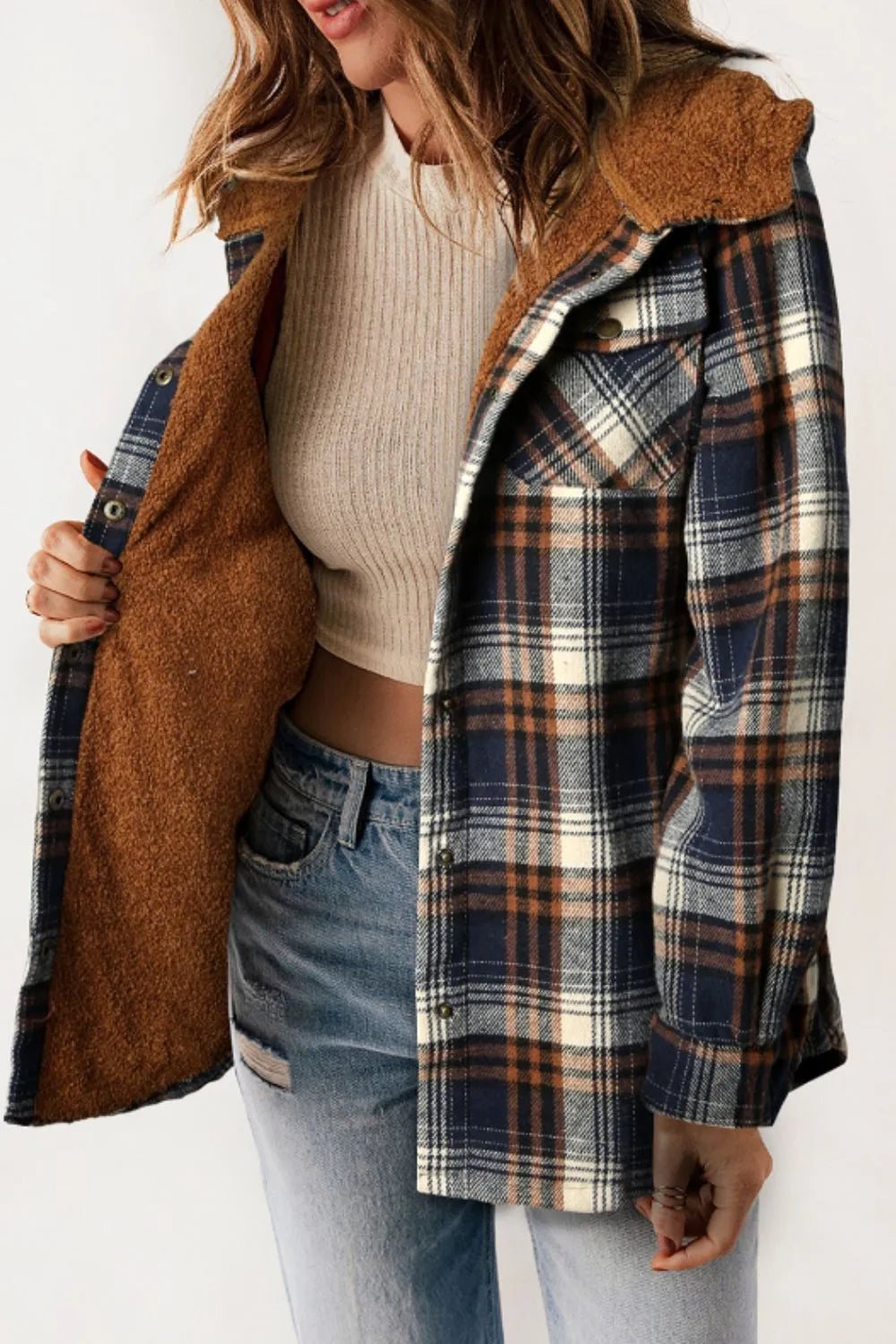 Person wearing a plaid jacket with brown lining on a white background