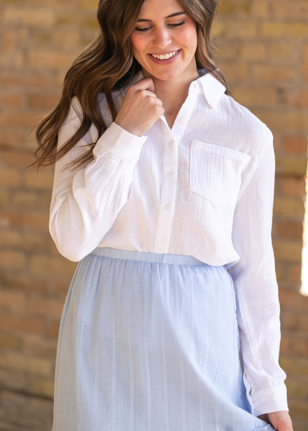 Woman wearing the Bailey crisp white cotton gauze button down top with a denim maxi skirt