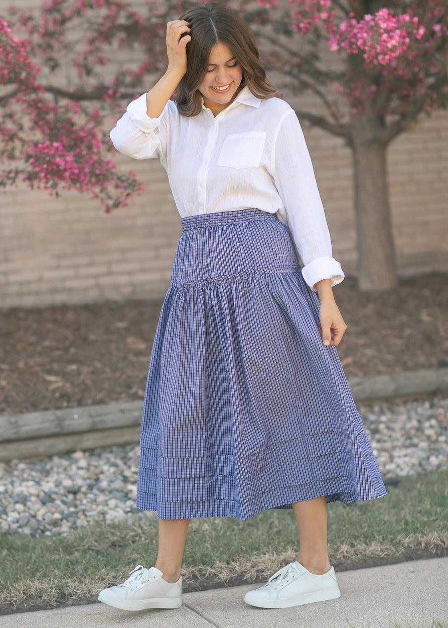 Woman wearing the Bailey crisp white cotton gauze button down top with a denim maxi skirt